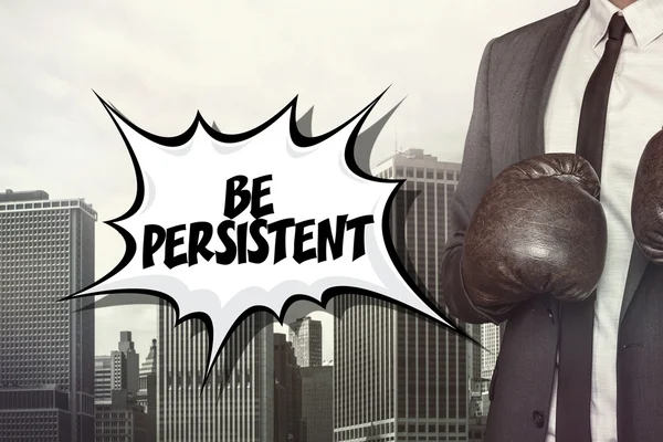 Be persistent text with businessman wearing boxing gloves — Stock Photo, Image