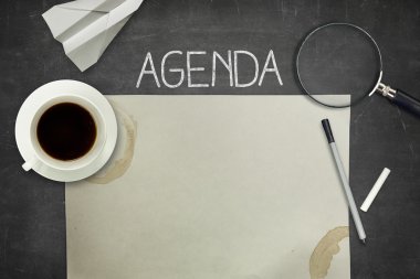 Agenda concept on black blackboard with empty paper sheet clipart