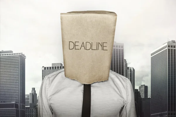 Deadline text on brown paper bag which businessman has on head — Stock Photo, Image