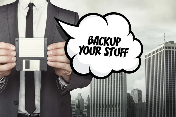 Back-up van uw spullen tekst op de tekstballon met zakenman houden van diskette — Stockfoto
