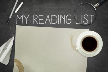 My reading list concept on black blackboard with empty paper sheet clipart