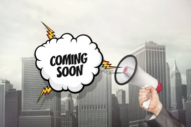 Metin üzerinde konuşma balonu ve işadamı el megafon tutarak coming soon