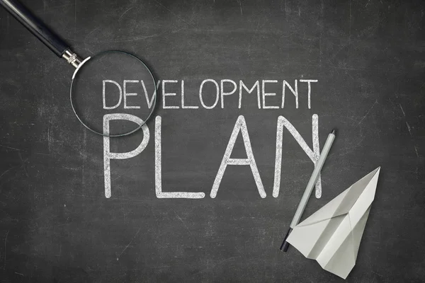 Fejlesztési terv fogalom fekete táblára üres papír lapot — Stock Fotó