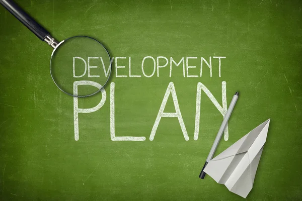Development plan concept on green blackboard with empty paper sheet