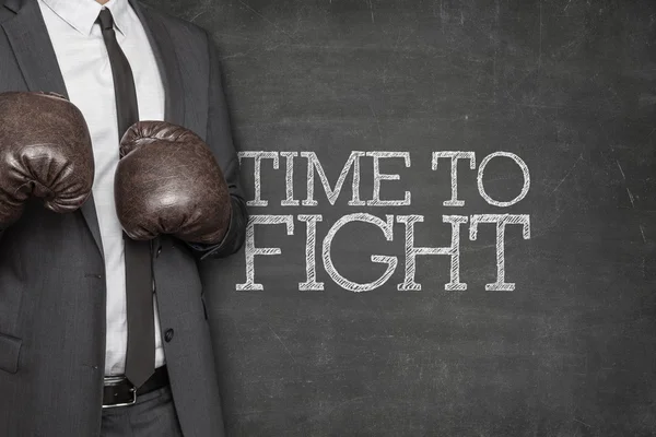 Time to fight on blackboard with businessman on side