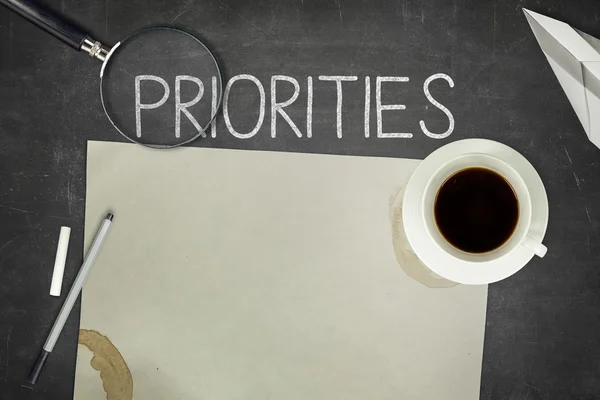 Priorities concept on black blackboard — Stock Photo, Image