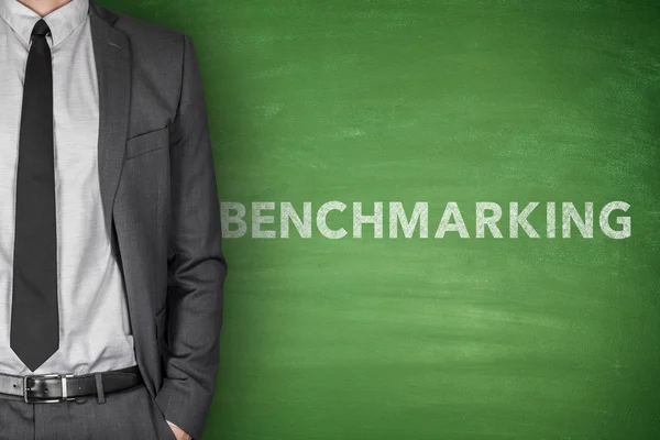 Benchmarking text on black blackboard — Stock Photo, Image