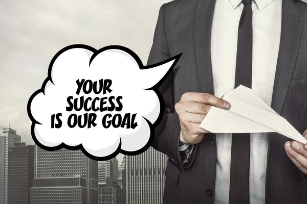 Your success is our goal text on speech bubble with businessman holding paper plane in hand — Stock Photo, Image