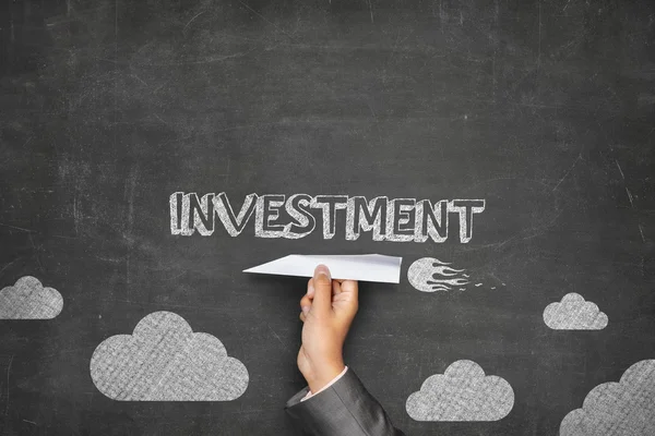 Investment concept on blackboard with paper plane — Stock Photo, Image