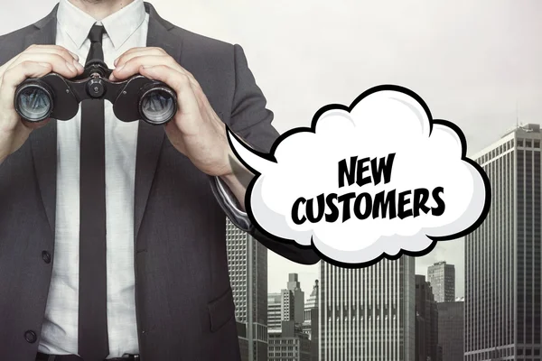 New customers text on speech bubble with businessman holding binoculars — Stock Photo, Image