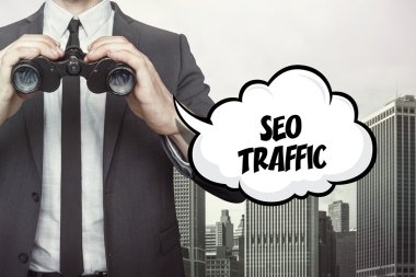 SEO trafik metin üzerinde dürbün tutan işadamı ile konuşma balonu