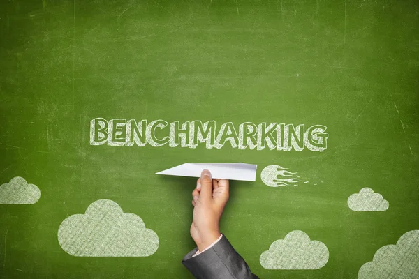 Benchmarking koncept på blackboard med papper plan — Stockfoto