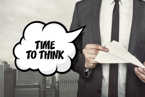 Time to think text on speech bubble with businessman holding paper plane in hand — Stock Photo, Image