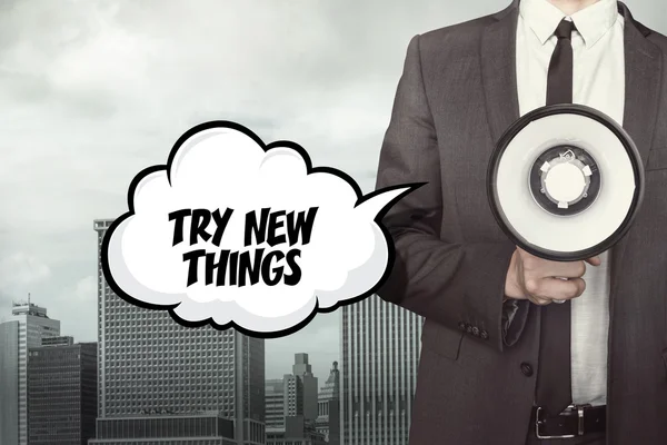 Try new things text on speech bubble with businessman holding paper plane in hand — Stock Photo, Image