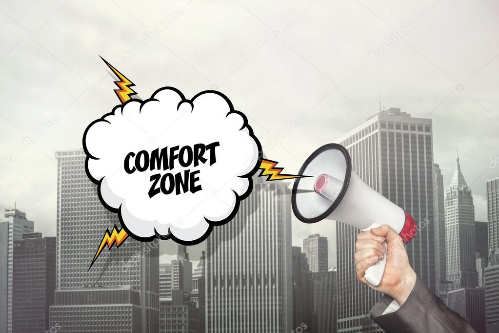 Comfort zone text on speech bubble and businessman hand holding megaphone