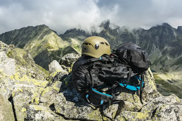 Casco in colore kaki scuro e nero zaino turisti in montagna . — Foto Stock