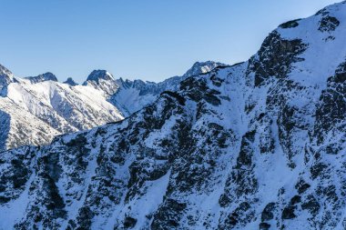 Kış manzarasında dağ sırtları ve dik yamaçlar.