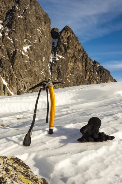 Machado de gelo e luvas na neve — Fotografia de Stock