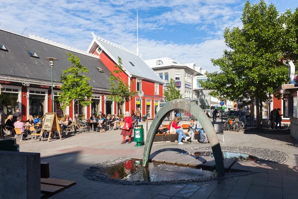 Praça em Reykjavik com uma fonte e cafés ao ar livre — Fotografia de Stock