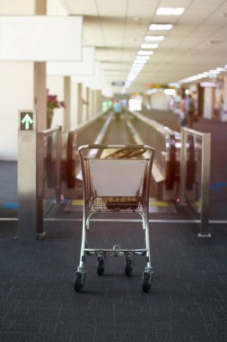 Havalimanı tramvayı krem renkli bir duvarın arkasında ve siyah bir halı boş park edilmiş. Veba salgını yüzünden insanların havaalanına gelmesini engelliyor.