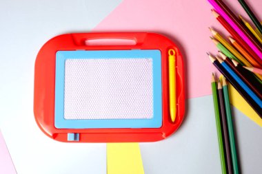 Parlak renkli kağıtta beyaz manyetik tahta okula gitmeye hazır.