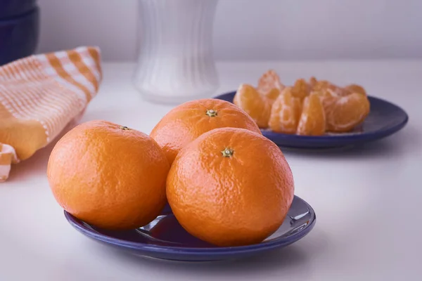 Turuncu mandalinalar yenmeye hazır. Turuncu meyve, taze ve doğal. Şekerli ya da şekersiz meyve. Mavi tabakta Clementines.