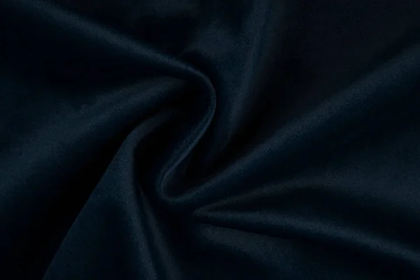 Donanma mavisi kumaş. Üst görünümü ve ezilmiş ve bükülmüş lacivert saten parçasının yakın görüntüsü.