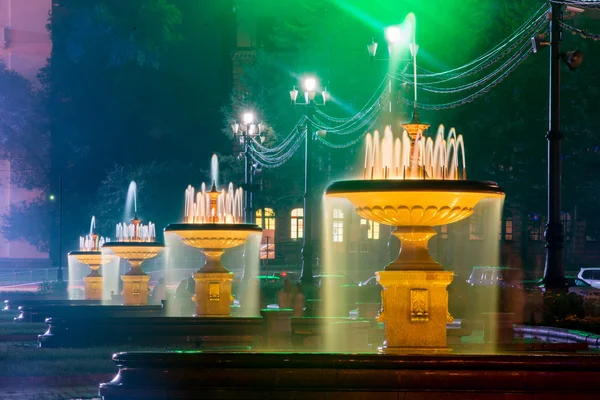 Fontes iluminadas na praça principal de Khabarovsk, Rússia  - — Fotografia de Stock