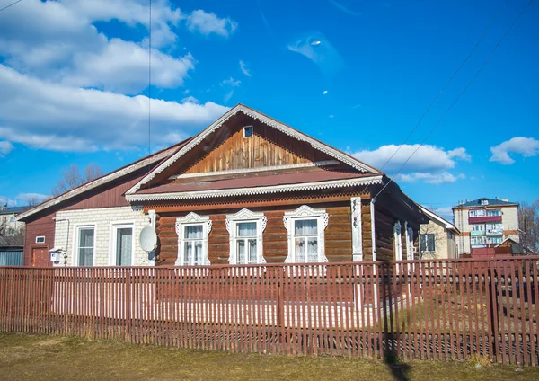 Eski kahverengi rustik evin arkasında bir çit mavi gökyüzü