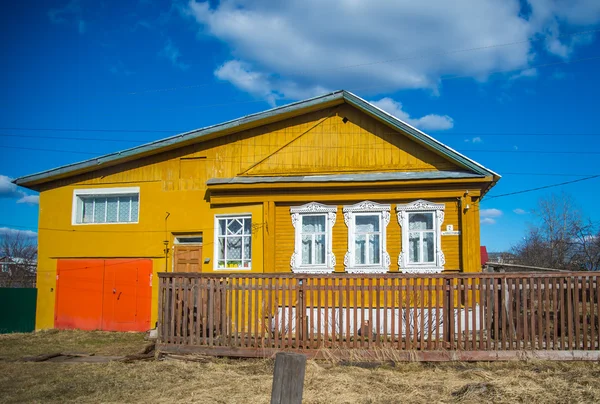 Eski sarı rustik evin arkasında bir çit mavi gökyüzü