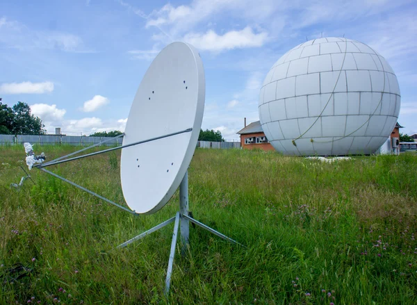 Weiße Satellitenschüsseln auf grünem Gras und blauem Hintergrund — Stockfoto