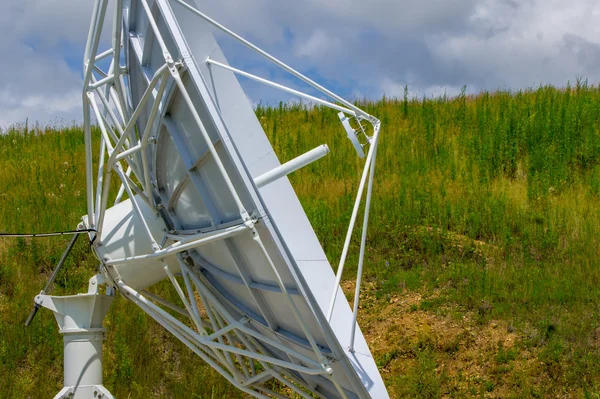 Witte satelliet dishs op de achtergrond van groen gras en blauw — Stockfoto