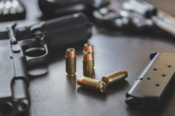 .45 Kaliber Hohlpunktkugeln in der Nähe von Handfeuerwaffe und Magazin auf le — Stockfoto