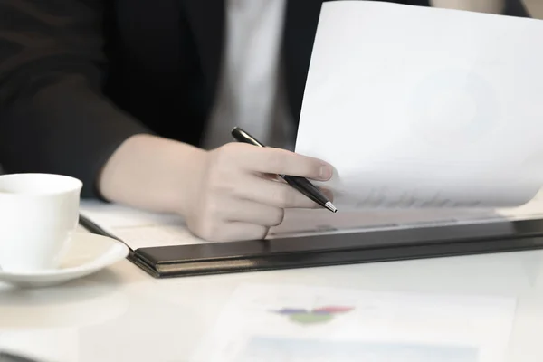 Closeup to hand business woman hold pen and financial document — Stock Photo, Image