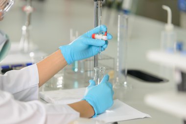 Bilim adamı olan kadınla laboratuvarda titrasyon tekniği göstermek