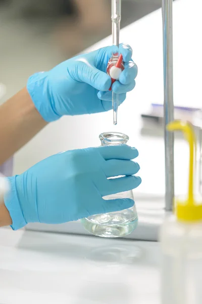 Bilim adamı olan kadınla laboratuvarda titrasyon tekniği göstermek