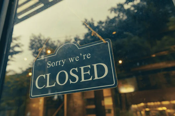 SORRY WE ARE CLOSED - Close sign broad hanging front of entrance door with copy space at coffee shop or restaurant