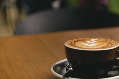 Kafe 'de üzerinde güzel latte sanat eserleri olan bir fincan taze kahve ve fotokopi alanı. Kahve molası rahatlama