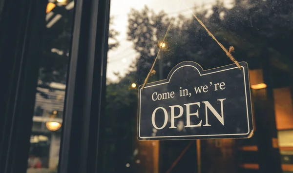 COME IN, WE ARE OPEN - Open sign broad hang on entrance door with copy space at coffee shop or restaurant