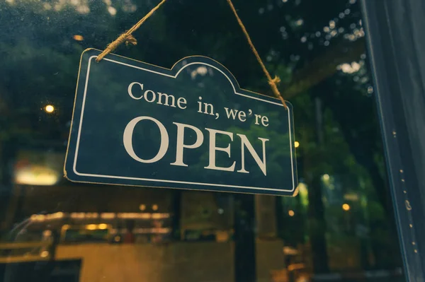 COME IN, WE ARE OPEN - Open sign broad hang on entrance door with copy space at coffee shop or restaurant