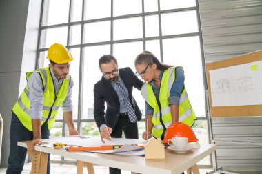 Mimari proje için mühendis ekibi toplantısı. Mimarlar ofis çalışanları konferans alanında inşaat yöneticisiyle planlarını tartışıyor. İnşaat Konsepti