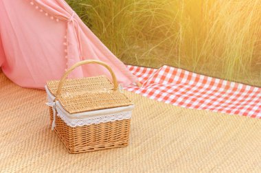 Parkta örülmüş ahşap piknik sepeti. Yaz güneşli bir gün ve piknik zamanı konsepti