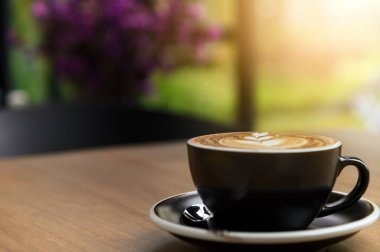 Kafe 'de üzerinde güzel latte sanat eserleri olan bir fincan taze kahve ve fotokopi alanı. Kahve molası rahatlama