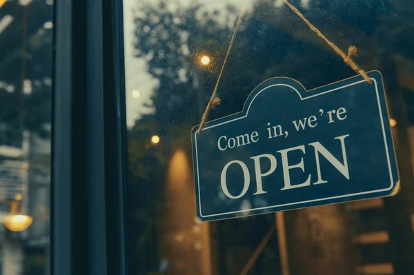 COME IN, WE ARE OPEN - Open sign broad hang on entrance door with copy space at coffee shop or restaurant