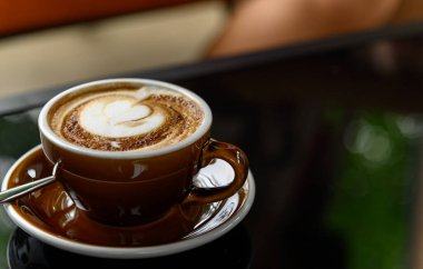 Kafe 'de üzerinde güzel latte sanat eserleri olan bir fincan taze kahve ve fotokopi alanı. Kahve molası rahatlama