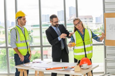 Mimari proje için mühendis ekibi toplantısı. Mimarlar ofis çalışanları konferans alanında inşaat yöneticisiyle planlarını tartışıyor. İnşaat Konsepti