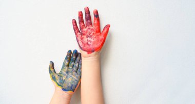 Renkli boyalı beyaz arka planda izole edilmiş iki çocuk eli. Yaratıcı, eğlenceli, sanatsal ve mutlu