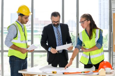 Mimari proje için mühendis ekibi toplantısı. Mimarlar ofis çalışanları konferans alanında inşaat yöneticisiyle planlarını tartışıyor. İnşaat Konsepti