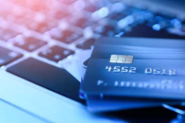 Bilgisayardaki kredi kartının çevrimiçi mağazalardan ve çevrimiçi alışveriş için yapılan ödemeleri yakından çek. İnternet alımı kavramı. Mavi renk tonu ve arkaplan için seçici odak