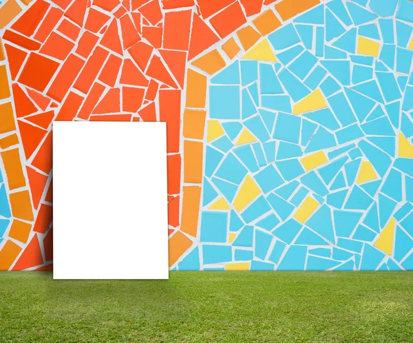 空ポスター カラフルなモザイク タイル壁と情報メッセージのための緑の芝生 — ストック写真